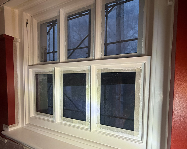 empty bedroom with a white bed frame green walls and natural light from the window suggesting cozy five star living