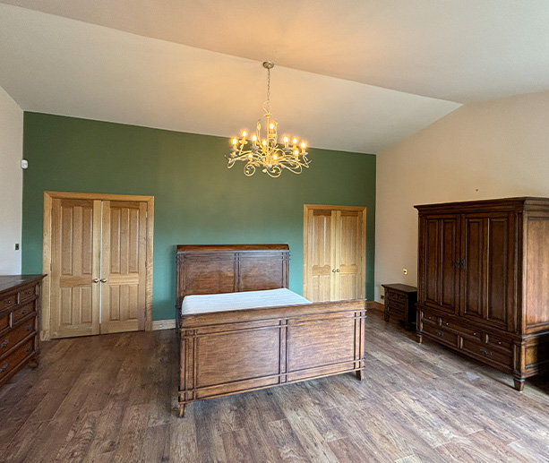 a decorative brass chandelier with multiple light bulbs hanging from a ceiling in a room featuring two elegant wall panels and a neutral color scheme
