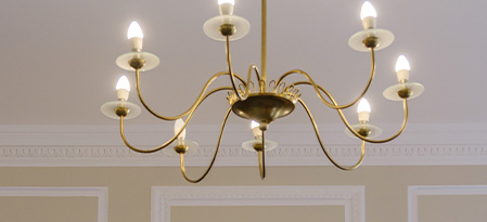 interior of a room featuring a covered sofa plastic sheeting and art supplies with a backdrop of wall decor this space is being prepared for a design project six items can be seen scattered around