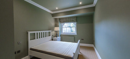 cozy living room with large window showcasing flowers and vintage decor featuring eight colorful pillows and artwork